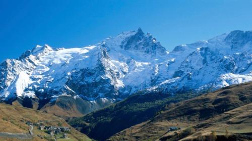 a snow covered mountain with a group of people in front at LA MEIJE BLANCHE "RESIDENCE DE TOURISME 2 étoiles" in Villar-dʼArène