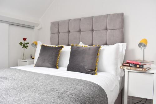 a bedroom with a large bed with a gray headboard at Apt 3, Opera House ensuite 4th Floor by Indigo Flats in London