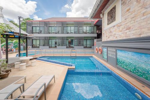 a swimming pool in front of a building at Chayadol Resort - SHA Extra Plus in Chiang Rai