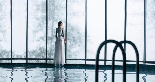a woman in a white dress standing in front of a window at Pao's Sapa Leisure Hotel in Sa Pa