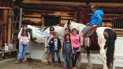 a group of children standing next to a horse at Villa Natur in Schröcken