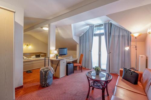 a hotel room with a bed and a desk at Richstein's Posthotel in Bad Füssing