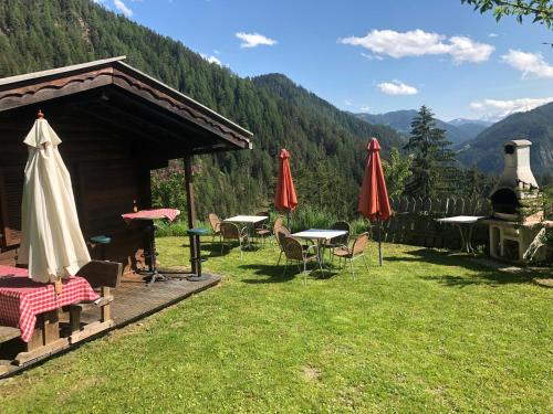 a group of tables and umbrellas in the grass at Fless in San Martino in Badia