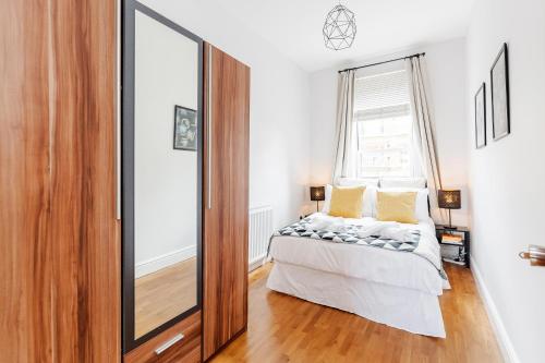 a bedroom with a mirror and a bed at WelcomeStay Clapham Junction 2 Bedroom Apartment in London
