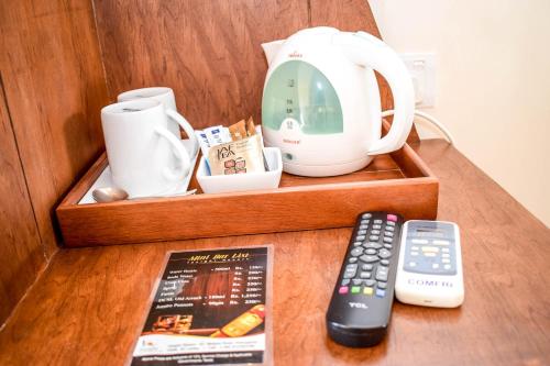 a wooden tray with a tea pot and a remote control at Insight Resort Ahangama - S&S Other Certified in Ahangama