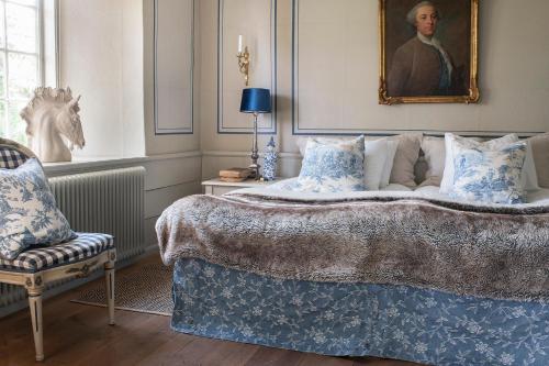 Un dormitorio con una cama y un retrato de un hombre en Västanå Slott, en Gränna