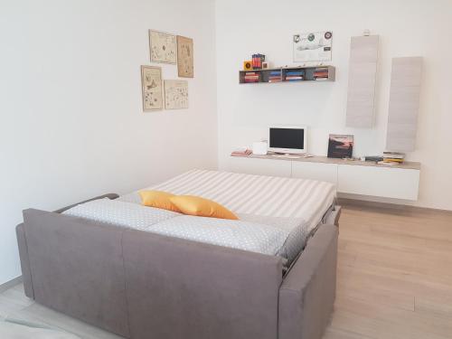 a bed in a room with a white wall at Appartamento La Casetta in Arona