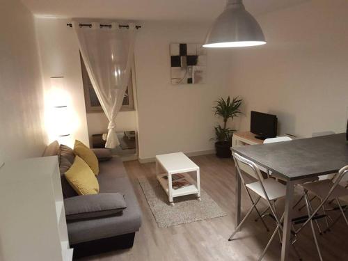 sala de estar con sofá y mesa de comedor en Très bel appartement Centre Vitré, en Vitré