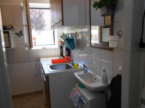a small kitchen with a sink and a window at Zsóka apartman in Hajdúszoboszló