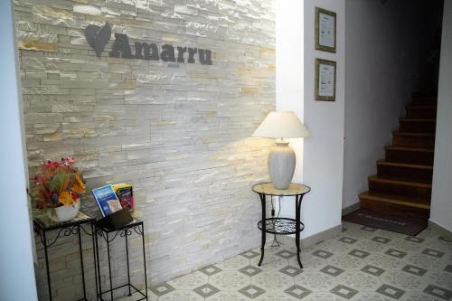 a lamp on two tables in front of a brick wall at Amarru Apartments in Piran