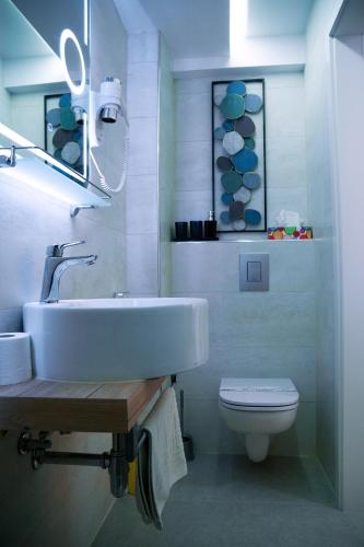 a white bathroom with a sink and a toilet at Amarru Apartments in Piran