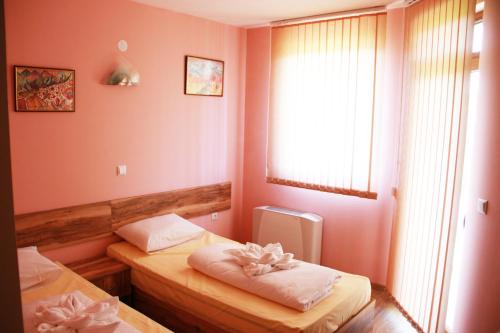 um quarto com duas camas e uma janela em Хотел АЛЕКСАНДЪР em Pavel Banya