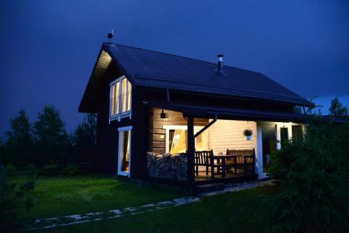 a small wooden house with a table in front of it at Kliukai in Dubingiai
