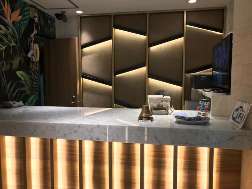 a kitchen with a counter top with gold cabinets at City Hotel Southern Cross in Tokyo