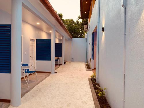 a hallway of a building with a table and chairs at Hudhuvelimaldives in Omadhoo