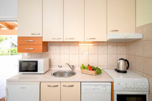a kitchen with a sink and a microwave at Apartments Roso - ZF Hvar in Hvar