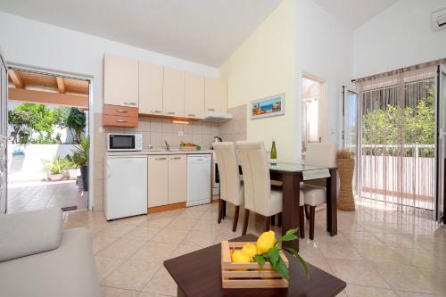 a kitchen and living room with a table and chairs at Apartments Roso - ZF Hvar in Hvar