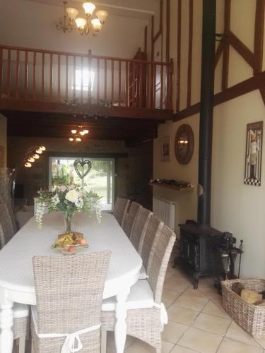 a dining room with a white table and chairs at Le Chene Vert in Millac