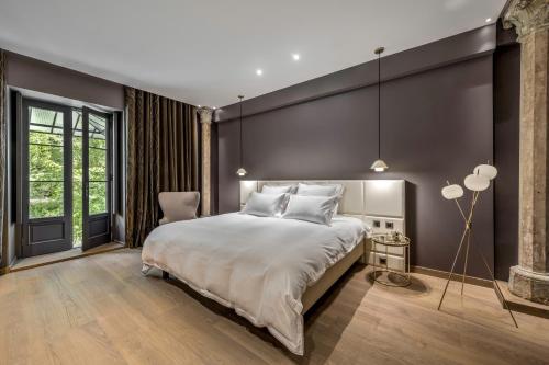 a bedroom with a large bed and a black wall at Les Suites de l'Ile Barbe in Lyon