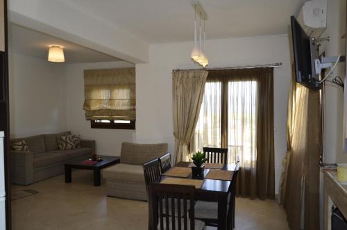 a living room with a couch and a table with chairs at Agnanti Villas in Nafpaktos