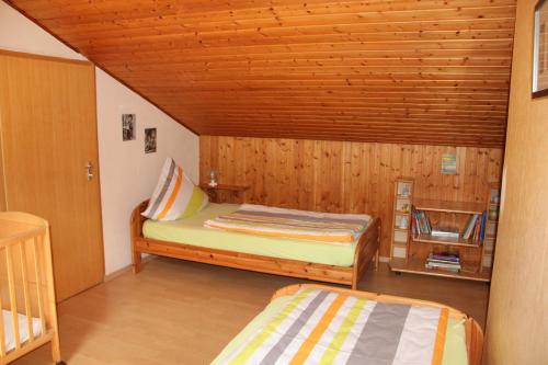 a bedroom with two beds and a wooden ceiling at Ferienhof Pöhlmann in Wunsiedel