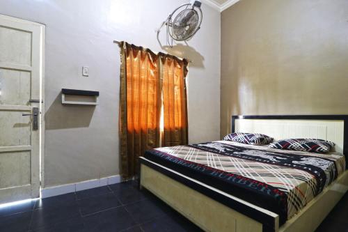 a bedroom with a bed and a window at Hotel Graha Soeltan in Sunggal