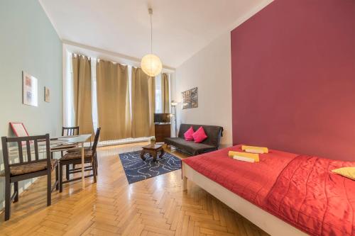 a bedroom with a red bed and a dining room at Miso Apartment in Budapest