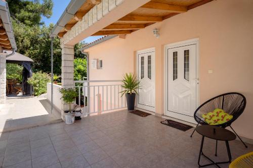 a patio with a white door and a chair at Apartments Roso - ZF Hvar in Hvar