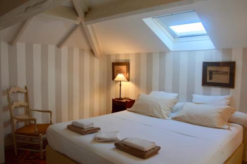 a bedroom with a large white bed with a skylight at Villa Côté Sud in Draguignan