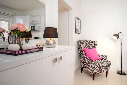 a white living room with a chair and a lamp at Apartments Roso - ZF Hvar in Hvar
