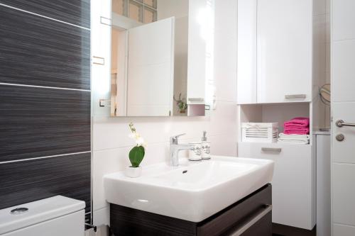 a bathroom with a white sink and a toilet at Apartments Roso - ZF Hvar in Hvar
