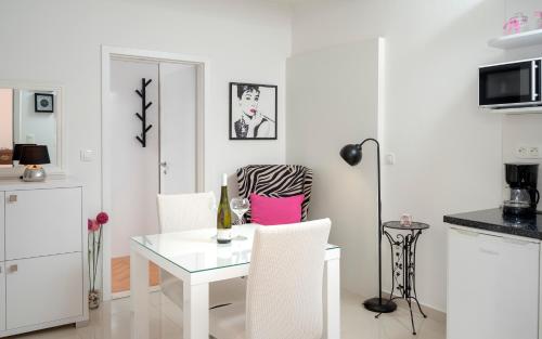 a white dining room with a white table and chairs at Apartments Roso - ZF Hvar in Hvar