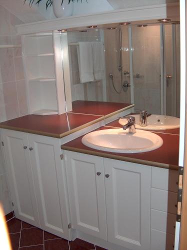 a white bathroom with a sink and a shower at Ferienwohnung Mayr in Thurn