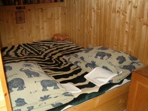 ゼベゲーニにあるElefántos Kis Mókus Házikóのシマウマ模様の毛布が備わる客室のベッド1台分です。