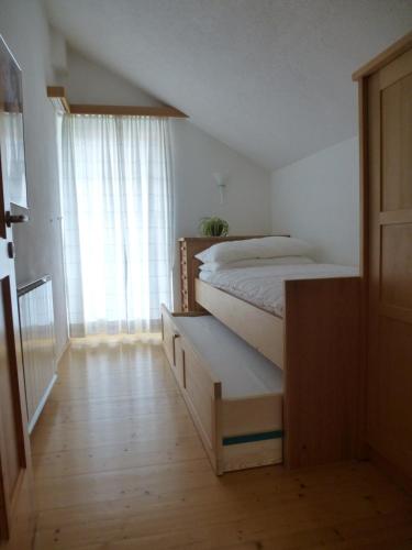 a bedroom with a bed and a dresser and a window at Ferienwohnung Mayr in Thurn