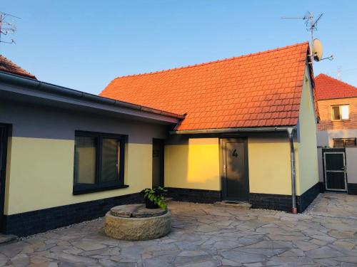a house with an orange roof and a courtyard at Ubytování V Zátiší Lednice in Lednice
