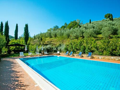 Una piscina con sillas y una montaña al fondo. en Holiday Home Villetta La Ginestra by Interhome, en La Collina