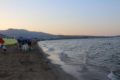 a group of people sitting on a beach with umbrellas at Marchica Apartment Nador Jadid Wifi Klima in Nador