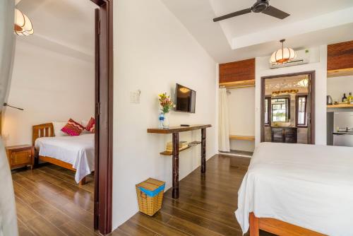 a room with two beds and a mirror at An Bang Coco Villa in Hoi An