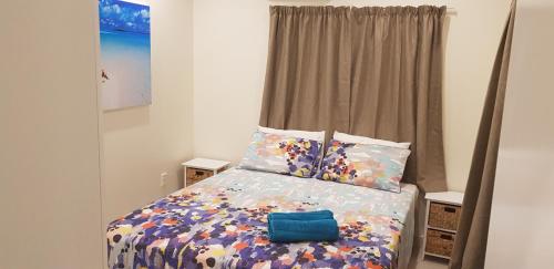 a bedroom with a bed with a blue bag on it at Te Etu Villa 1 in Rarotonga