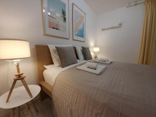 1 dormitorio con 1 cama grande, mesa y lámpara en Villa La Palmeraie Puerto de la Duquesa, en Manilva