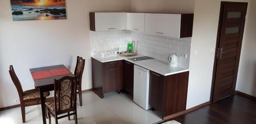 a small kitchen with a table and a counter top at Apartamenty Maja -Pokoje - Domy wakacyjne -Basen Podgrzewany -Jacuzzi in Łeba