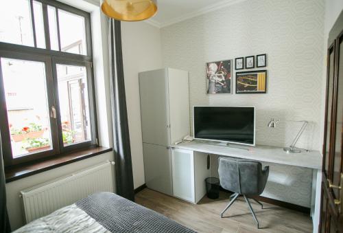 a bedroom with a desk with a computer on it at Chicago Vendégház in Szentes