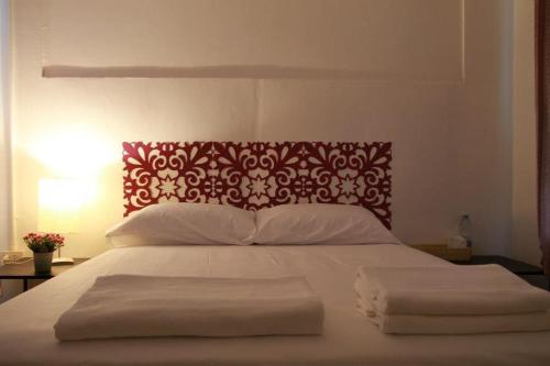 a large bed with a red and white head board at Baantalaywhan Resort in Ban Huai Yang