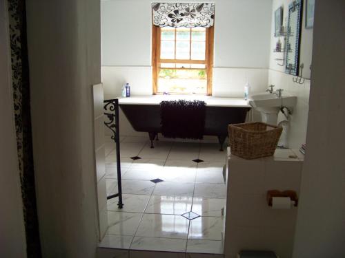 a bathroom with a bath tub and a window at Lemontree Cottage in Heidelberg