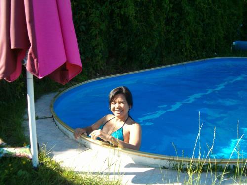 a young girl sitting in a swimming pool at Malomkerék Vendégház 1. in Zebegény