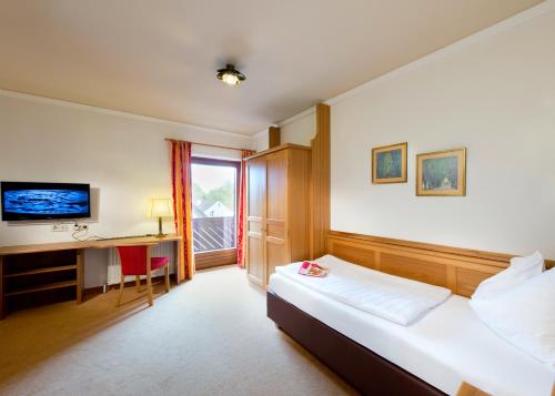 pokój hotelowy z łóżkiem i biurkiem w obiekcie Hotel St. Virgil Salzburg w mieście Salzburg