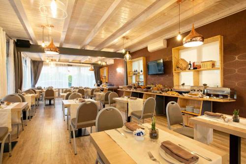 a dining room with tables and chairs in a restaurant at Simon Hotel in Pomezia