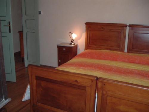 1 dormitorio con cama y mesita de noche con lámpara en Residenza Italia, en Casteldelfino