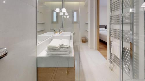 bagno bianco con lavandino e specchio di Central Acropolis View Apartment ad Atene